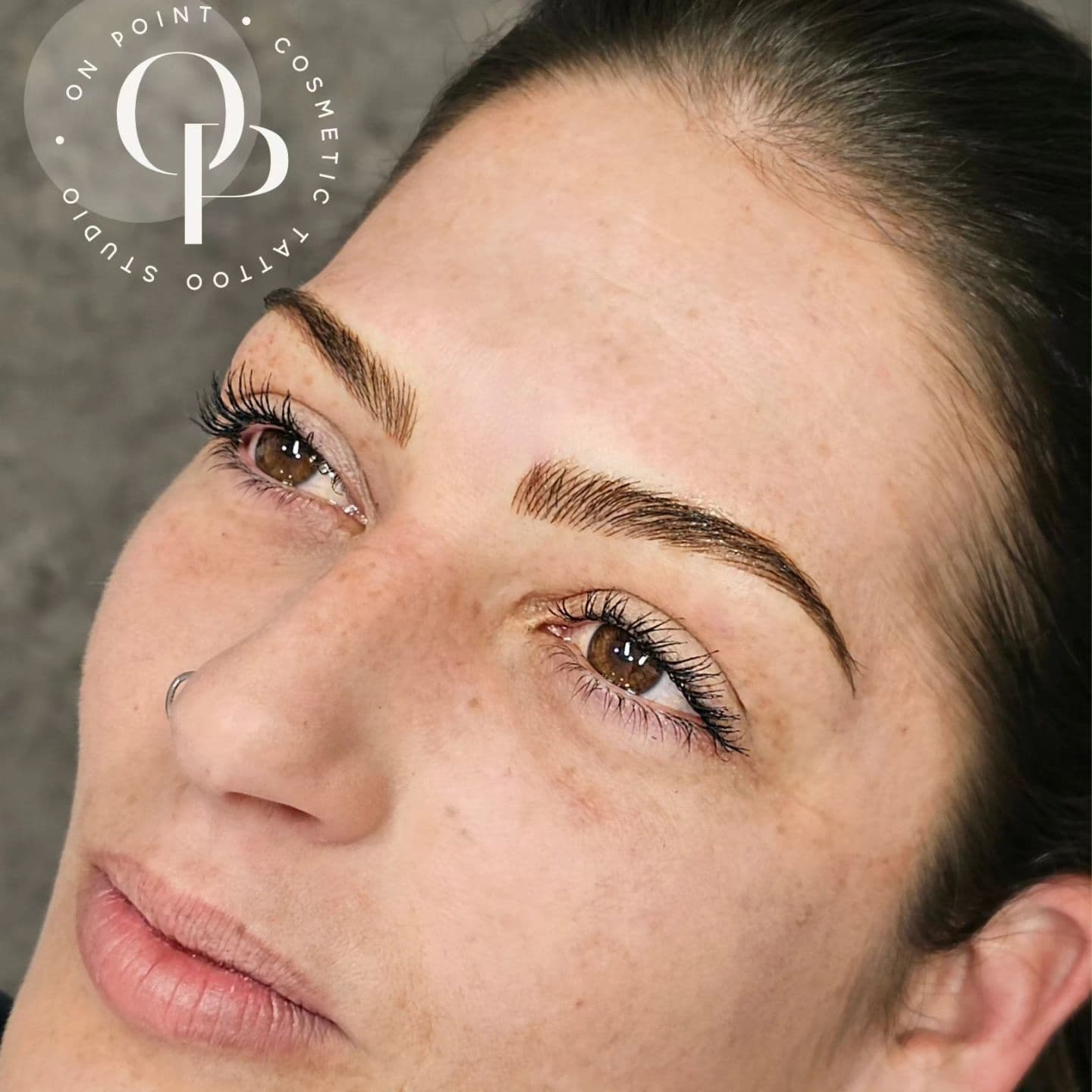 Feathered hair-stroke brows on a client with brown eyes