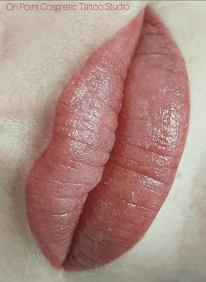 Lip tattoo in a muted rose, close up